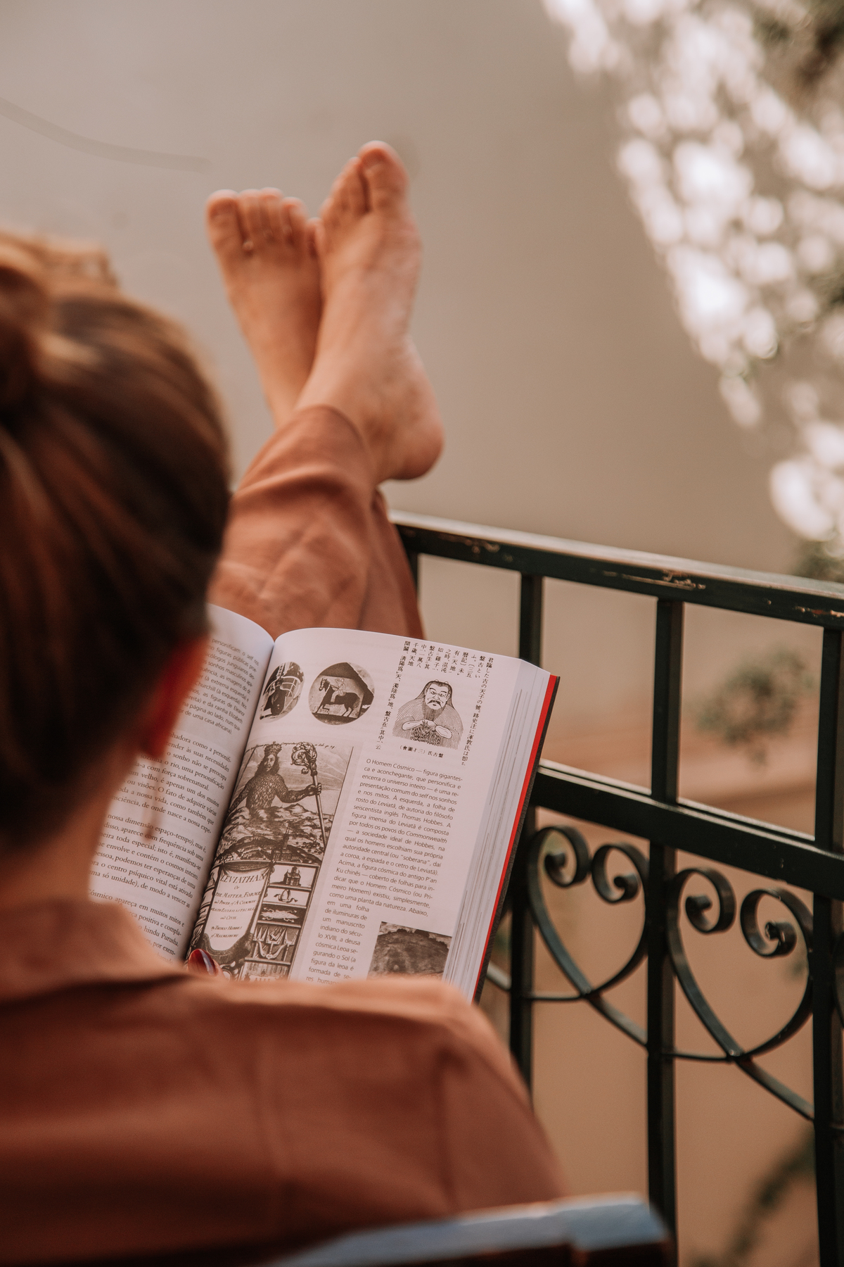 Mulher sentada lendo um livro em um café 