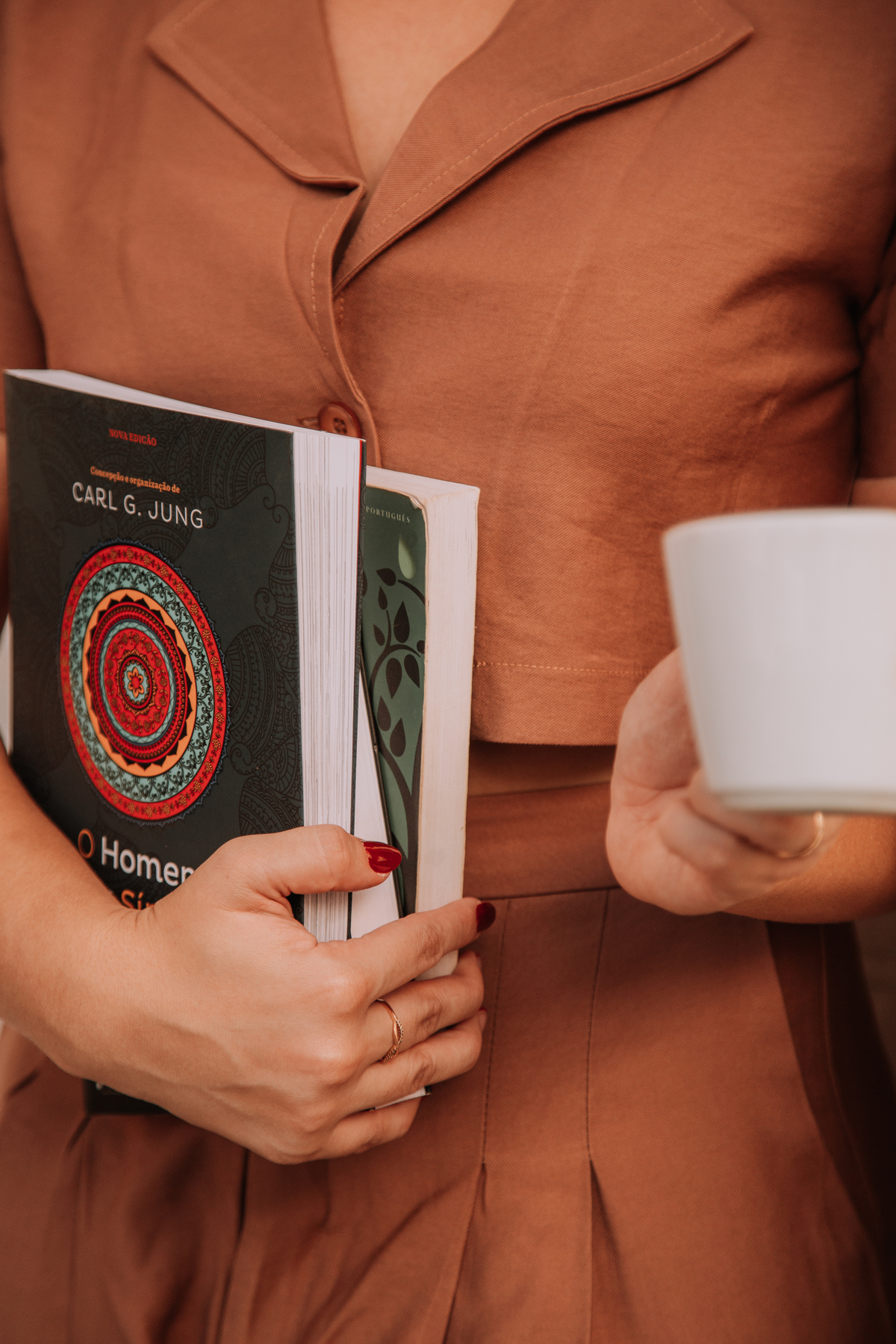 Mulher segurando livros e café em uma livraria em Jaú SP 