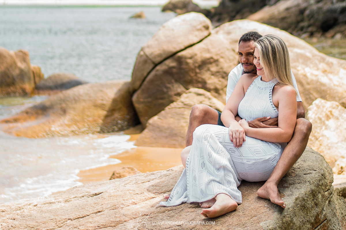 casal abraçado sentado na pedra em ensaio pré-wedding pré casamento na praia em Ubatuba litoral norte de são paulo