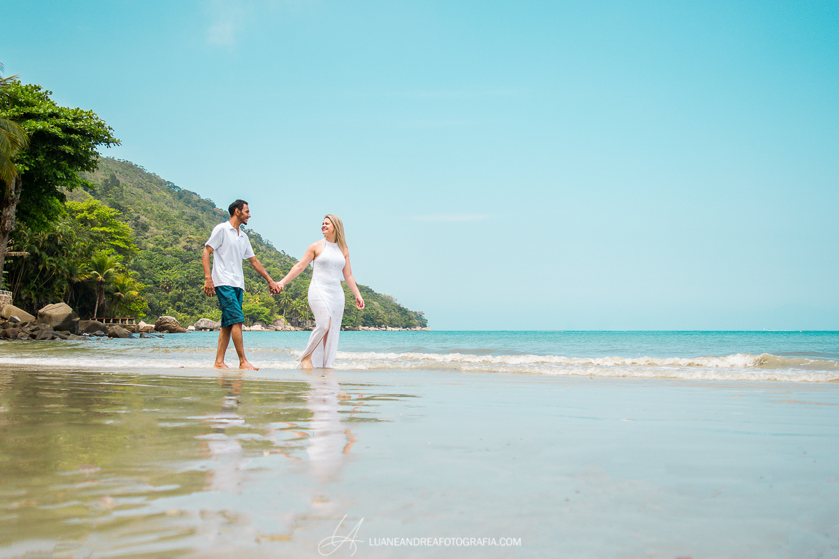 casal de noivos de mãos dadas caminhando na praia em ensaio pré-wedding pré casamento na praia em Ubatuba litoral norte de são paulo