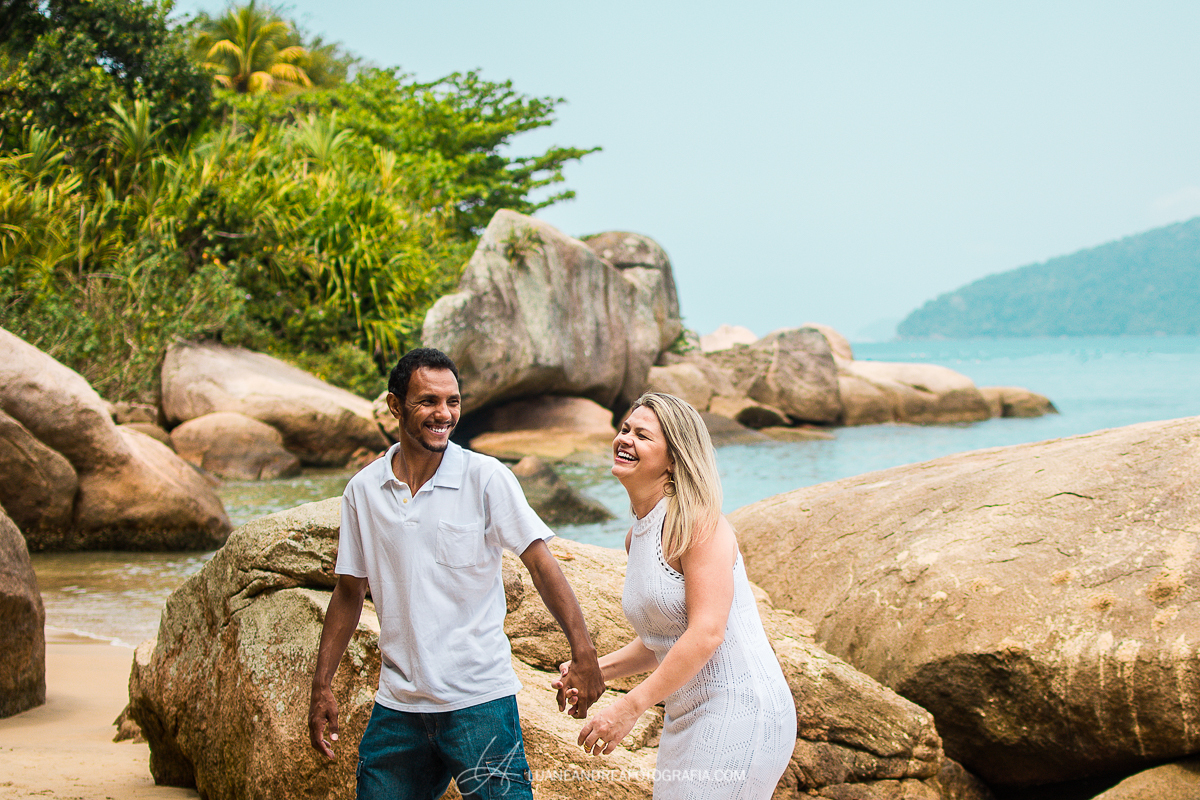 casal de mãos dados sorrindo em ensaio pré-wedding pré casamento na praia em Ubatuba litoral norte de são paulo
