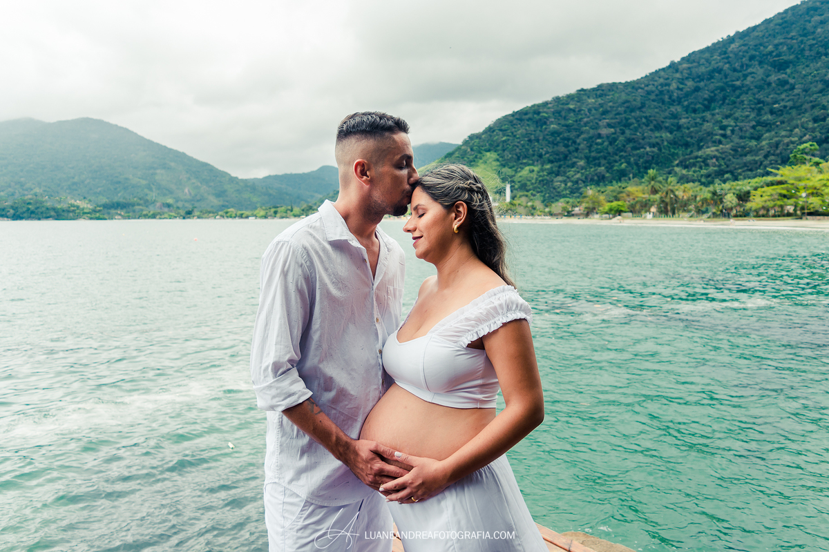 mulher grávida e marido beijando a testa na praia em ensaio gestante em ubatuba são paulo
