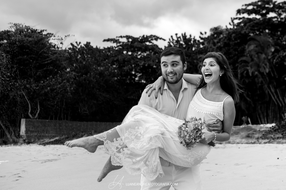 noivo com noiva no colo sorrindo em ensaio pré-wedding pré casamento na praia fim de tarde em ubatuba litoral norte de são paulo