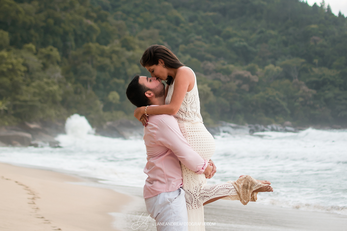 noivo com noiva no colo se beijando em ensaio pré-wedding pré casamento na praia fim de tarde em ubatuba litoral norte de são paulo