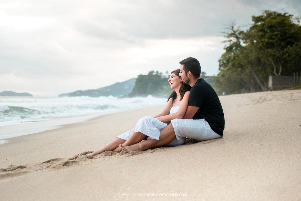 casal de noivos abraçados e sorrindo em ensaio pré-wedding pré casamento na praia fim de tarde em ubatuba litoral norte de são paulo