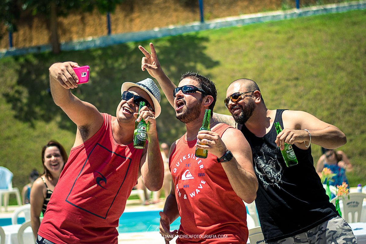 amigos fazendo um vídeo no celular e tomando cerveja em festa de aniversário de 40 anos em Taubaté