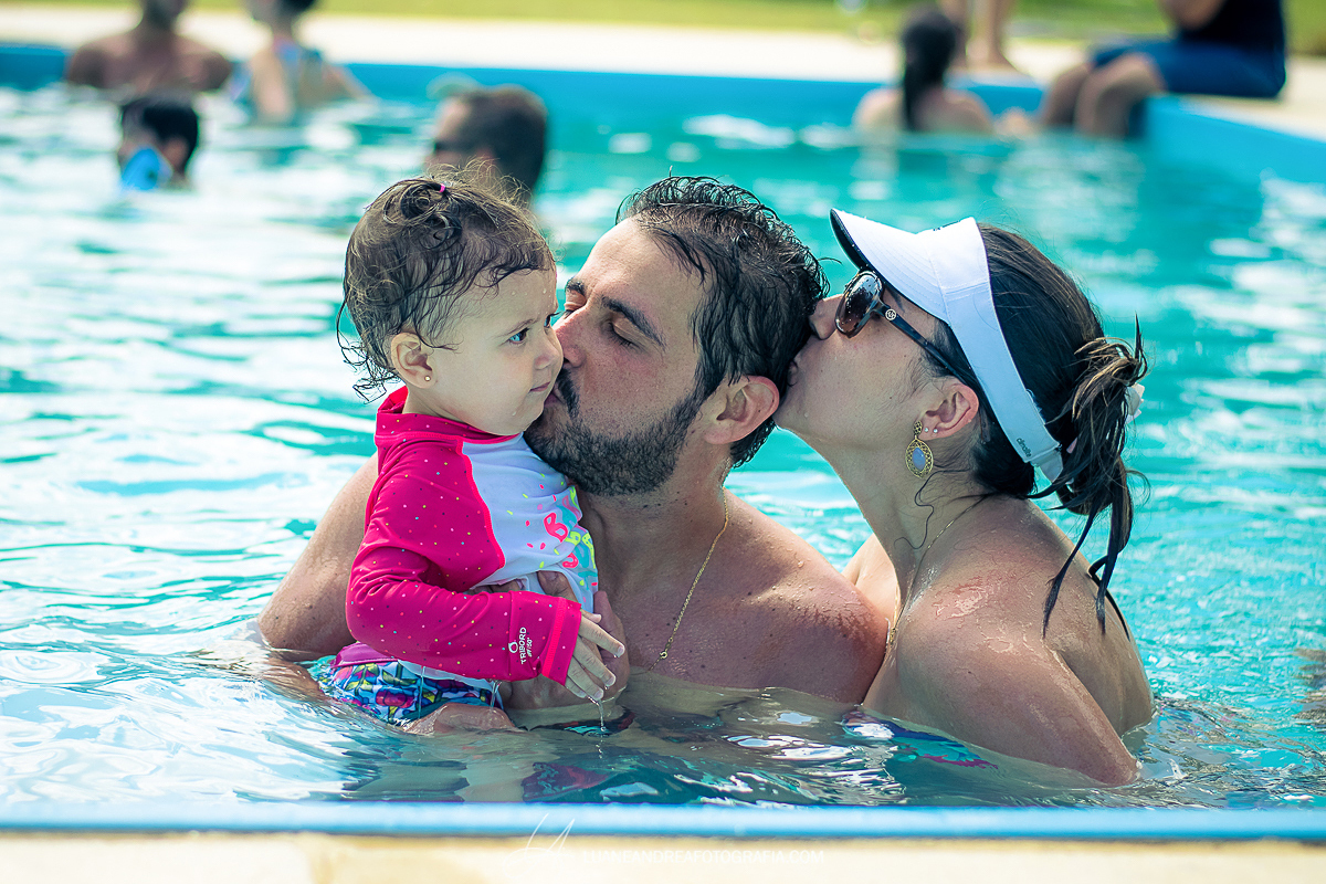pais com filha pequena na piscina em festa de aniversário de 40 anos em Taubaté
