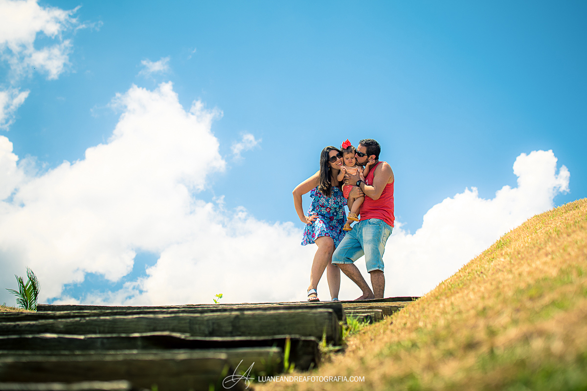 casal com filha no colo dando beijo no rosto em festa de aniversário de 40 anos em Taubaté