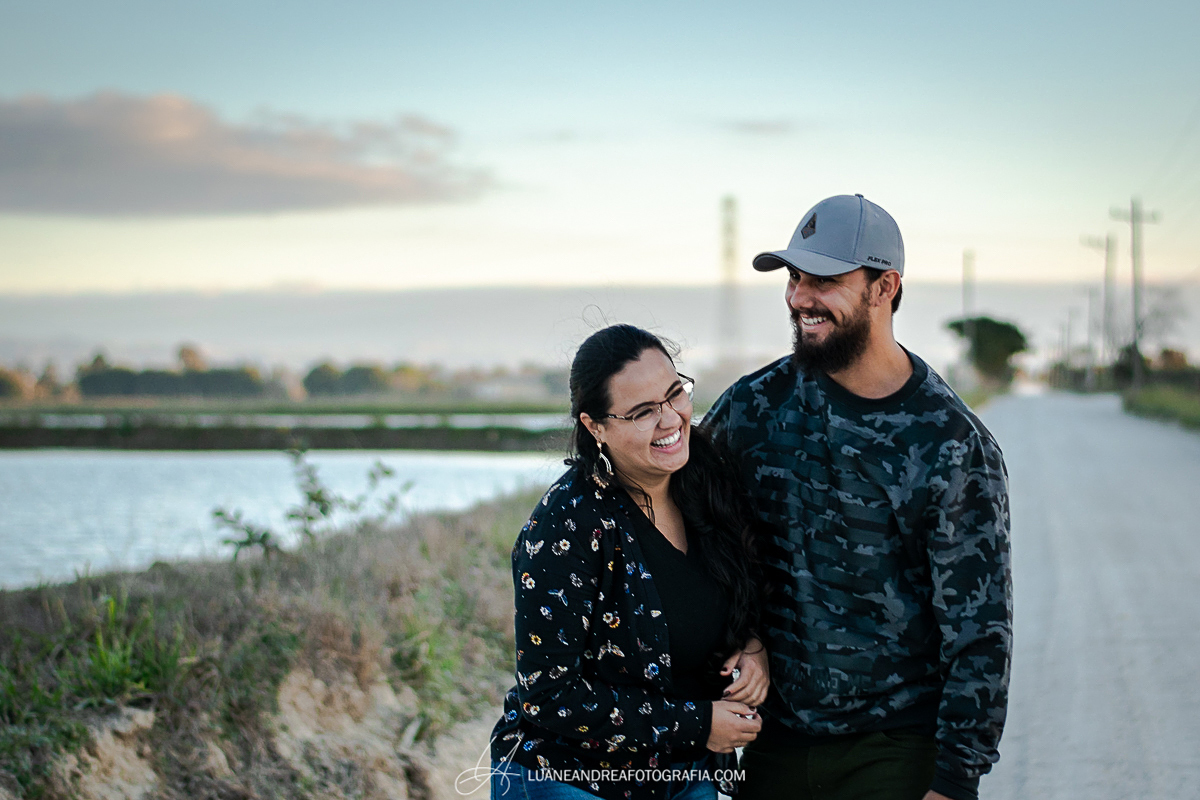 casal rindo no fim de tarde em ensaio pré wedding casamento no campo em taubaté são paulo