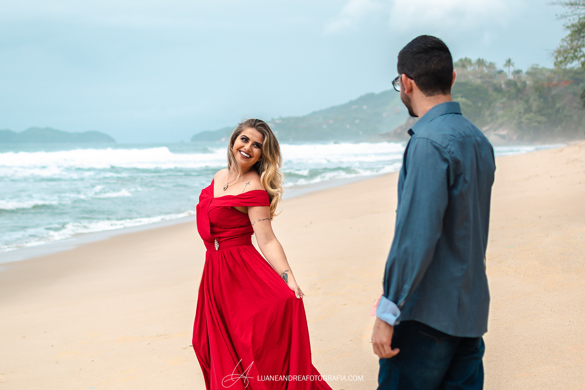 noiva olhando e sorrindo pro noivo na areia em ensaio pré wedding casamento na praia em Ubatuba litoral norte de são paulo