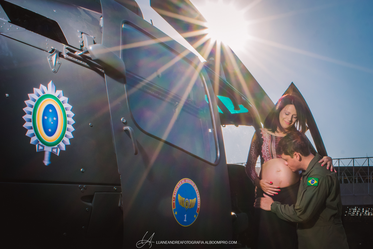 casal beijando a barriga em ensaio gestante no helicoptero no bavex em taubaté