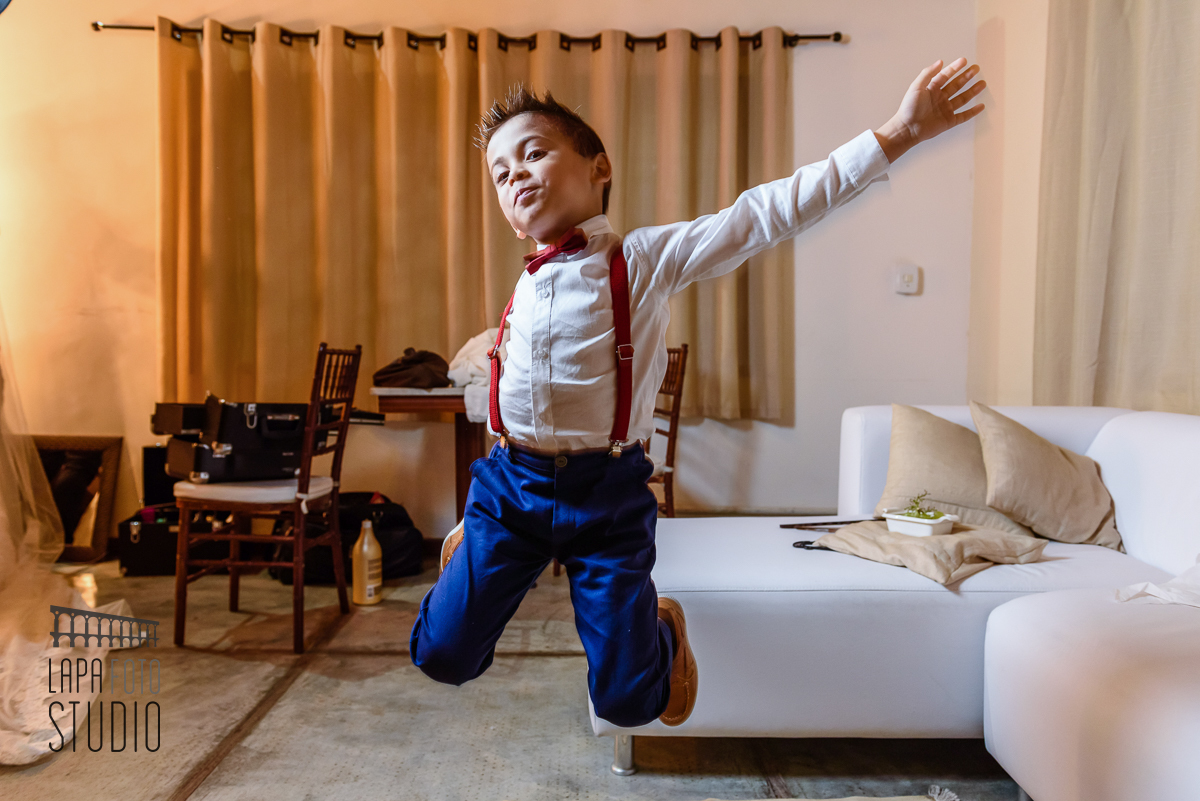 Criança feliz, pulando, no making of do pai.