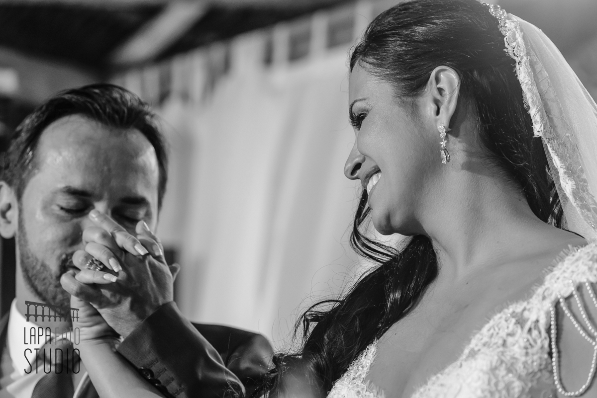 Noivo beijando a mão da noiva durante a cerimônia no Sítio Meio do Mato