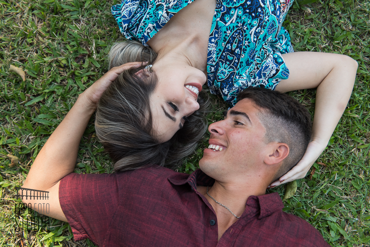 Noivos deitados na grama se olhando no dia do ensaio pré no Palácio Guanabara