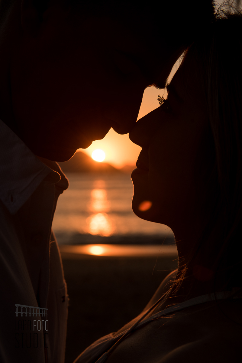Casal em contraluz com nascer do sol no dia do pré wedding na Praia Vermelha