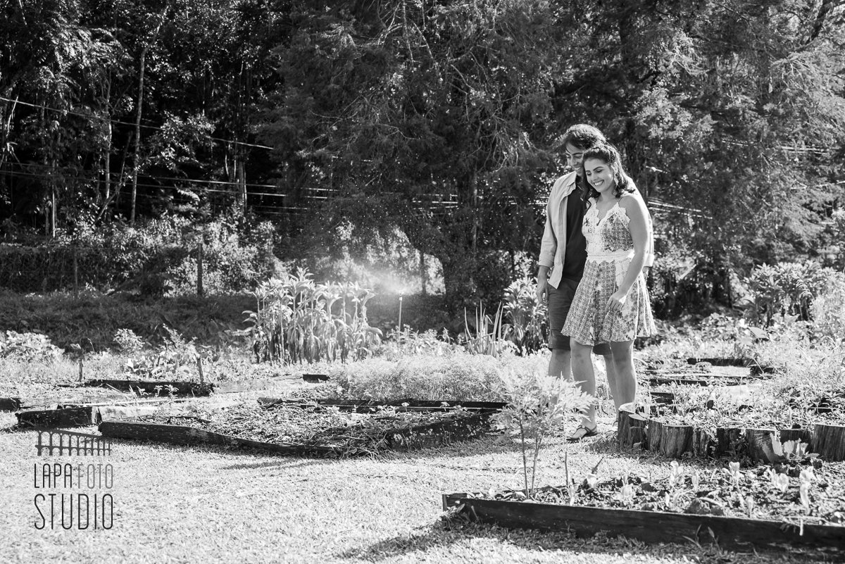 Foto em preto e branco dos noivos caminhando no meio da plantação no pré wedding em Friburgo