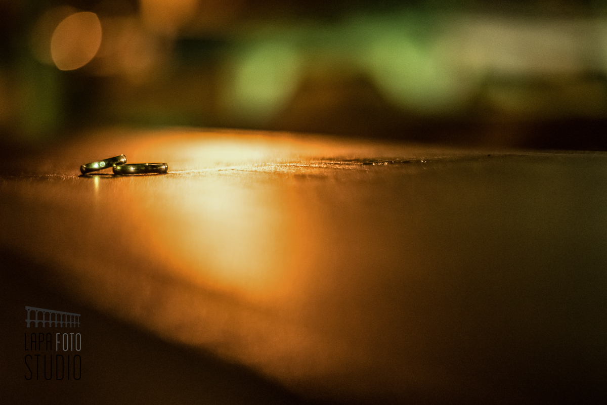 Alianças no banco de madeira com iluminação especial para destacá-las no casamento em Friburgo.
