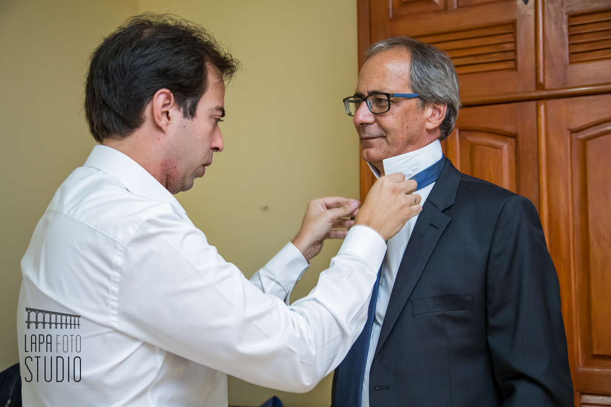 Noivo arrumando a gravata do seu pai na preparação para o casamento