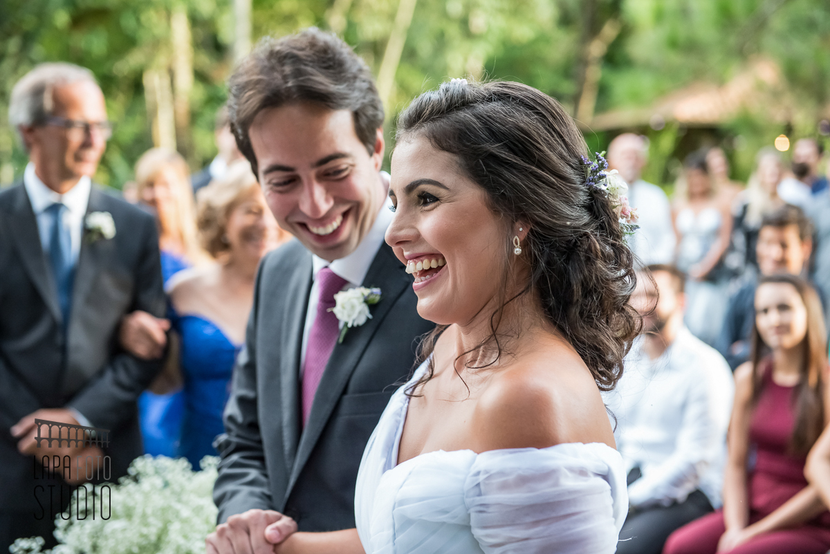 Noivos sorridentes em cerimônia de casamento no Trilhas do Araçari.