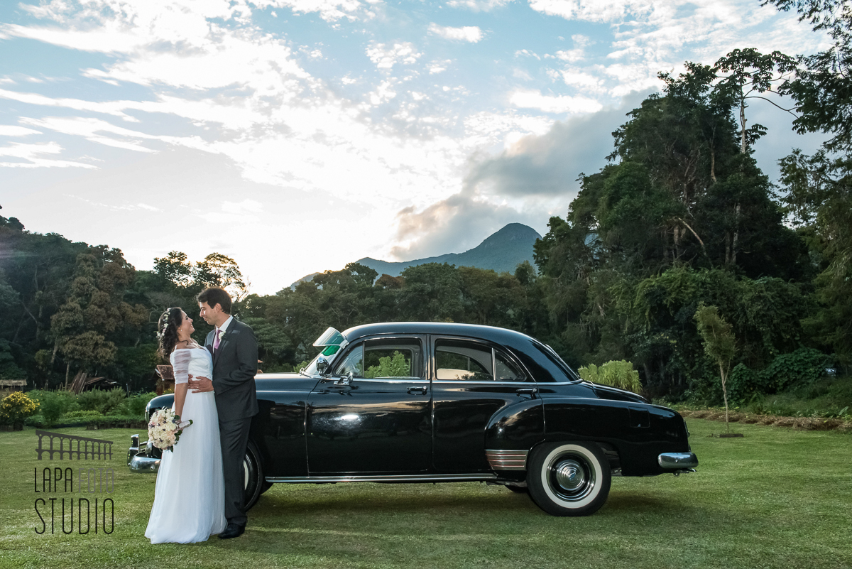 Casal no ensaio ao lado do carro antigo alugado para o casamento na serra.