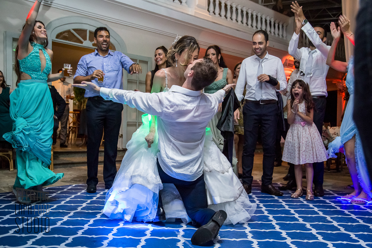 Noivo se ajoelha na pista e beija a noiva no dia do casamento na Mansão das Heras