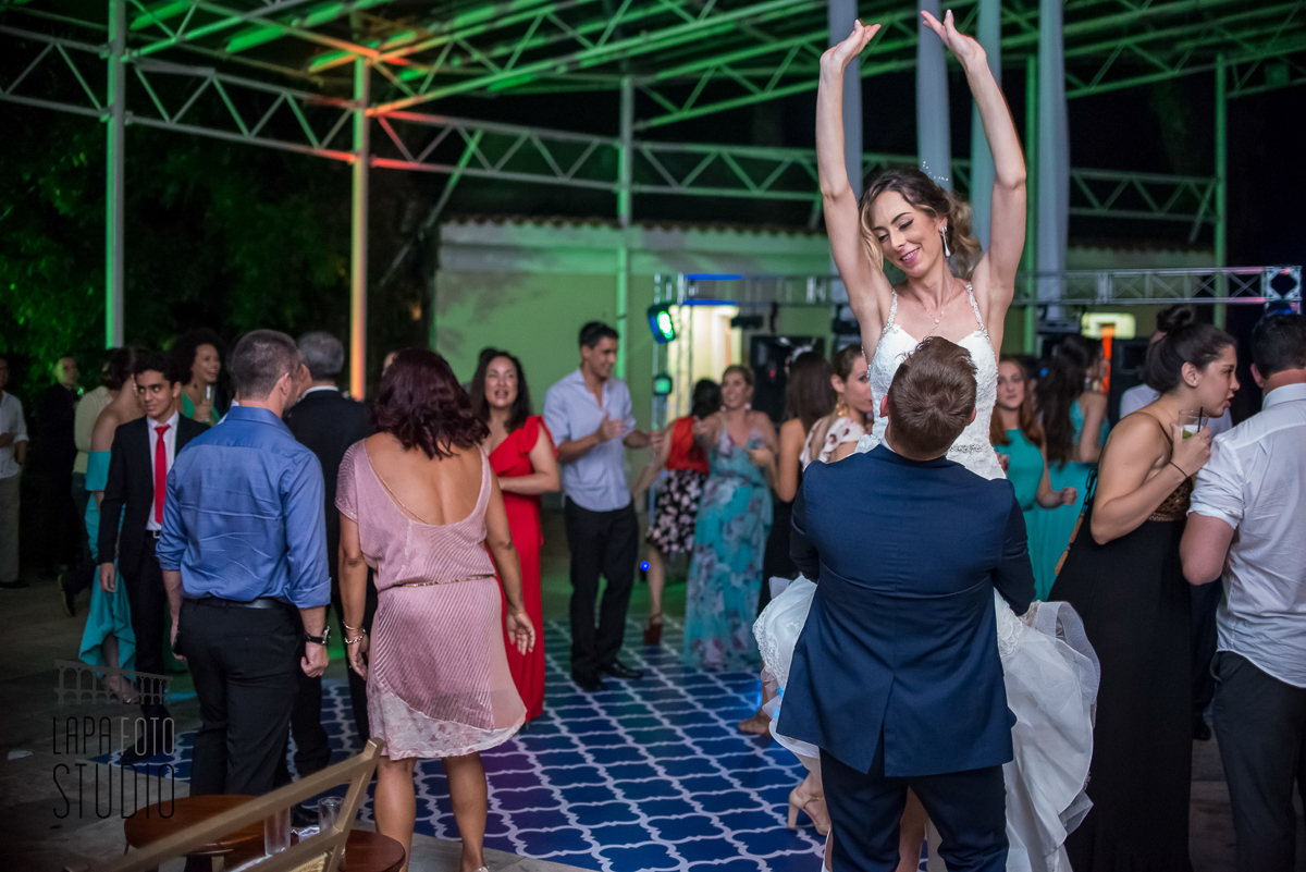 Noivo pega a noiva no colo na pista de dança no dia do casamento