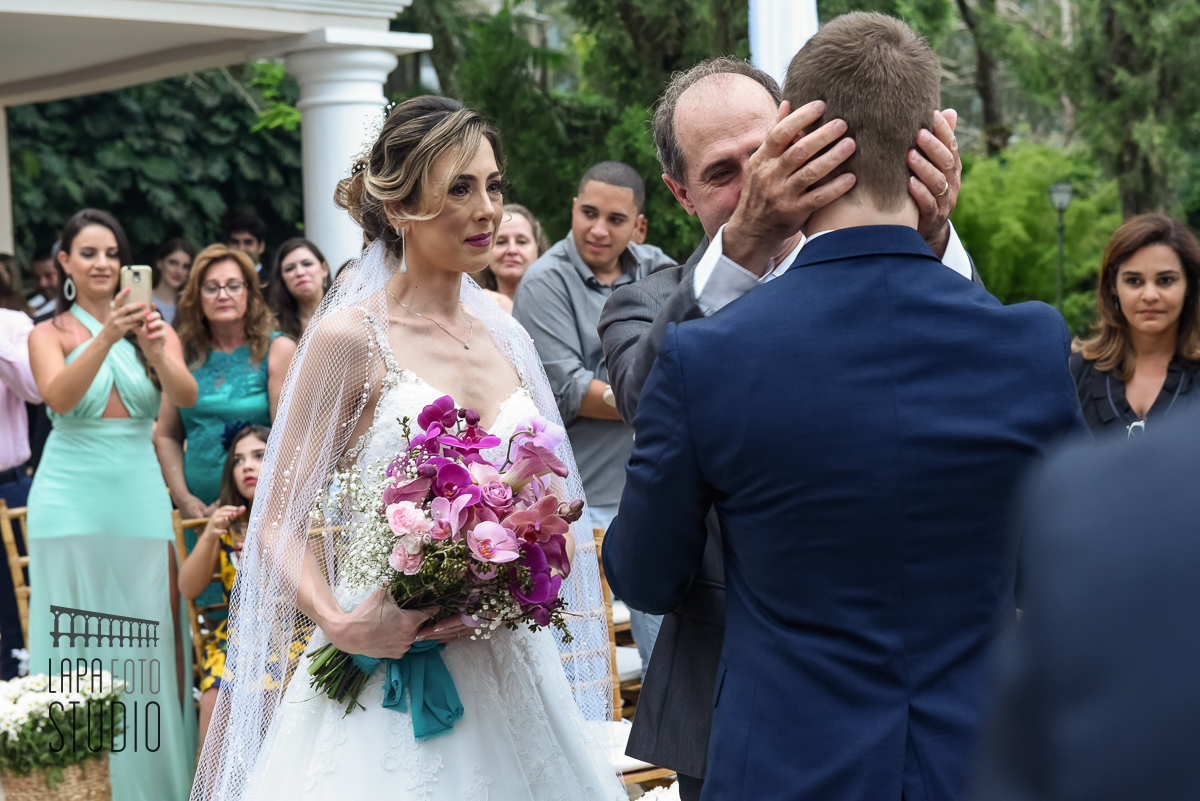 Abraços do pai da noiva no noivo após entrada do casamento