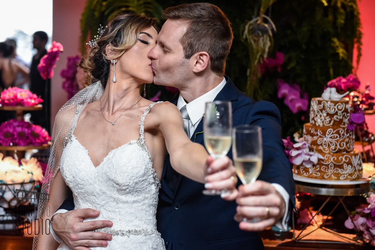 Brinde dos noivos com beijo na mesa decorada para casamento