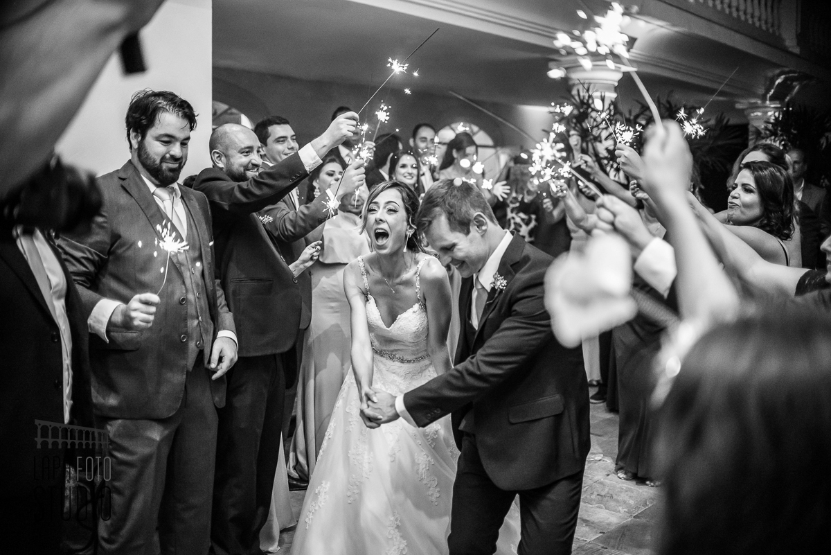 Foto em preto e branco da entrada dos noivos na festa num corredor de sparkles