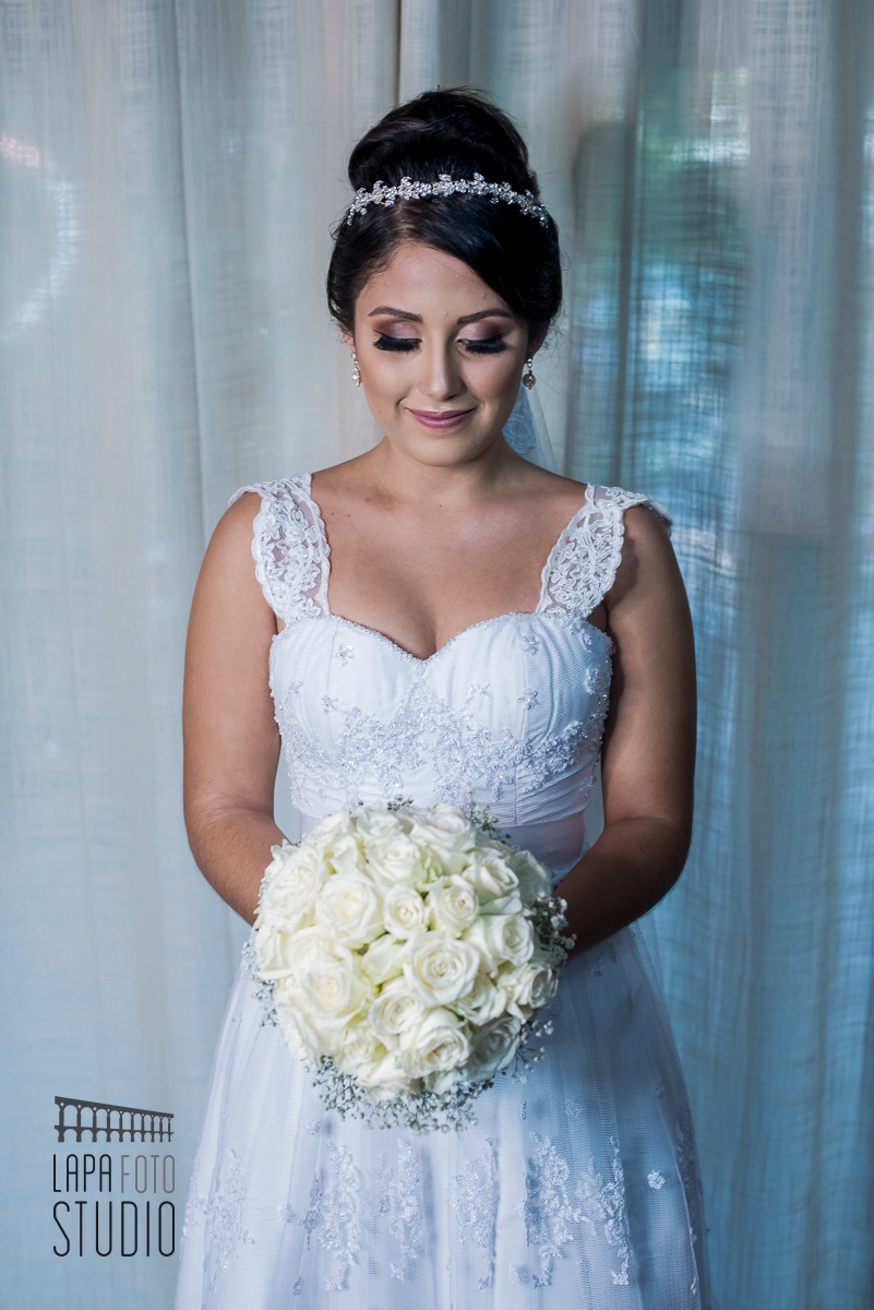 Noiva pronto olhando para o buquê logo após seu making of