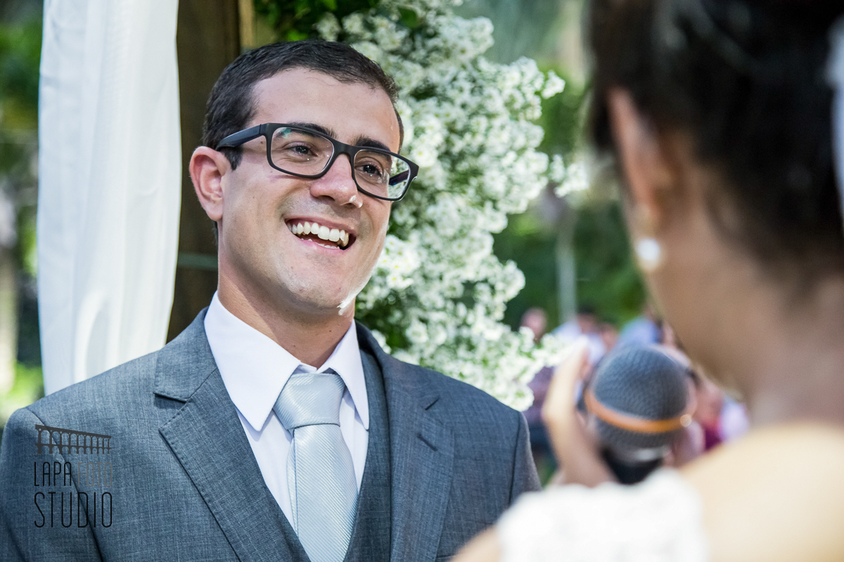 Noivo sorri para a noiva durante seus votos na cerimônia de casamento