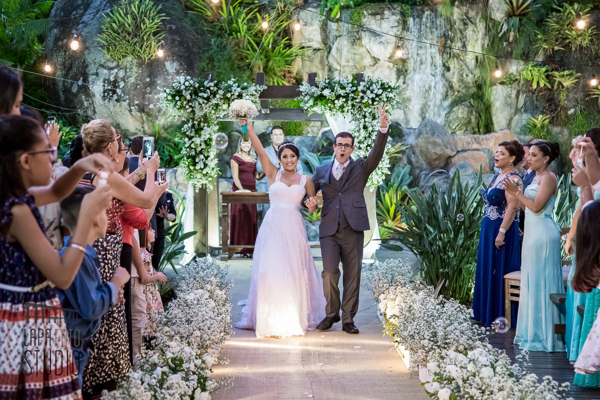 Noivos comemorando durante a saída da cerimônia no vale dos sonhos