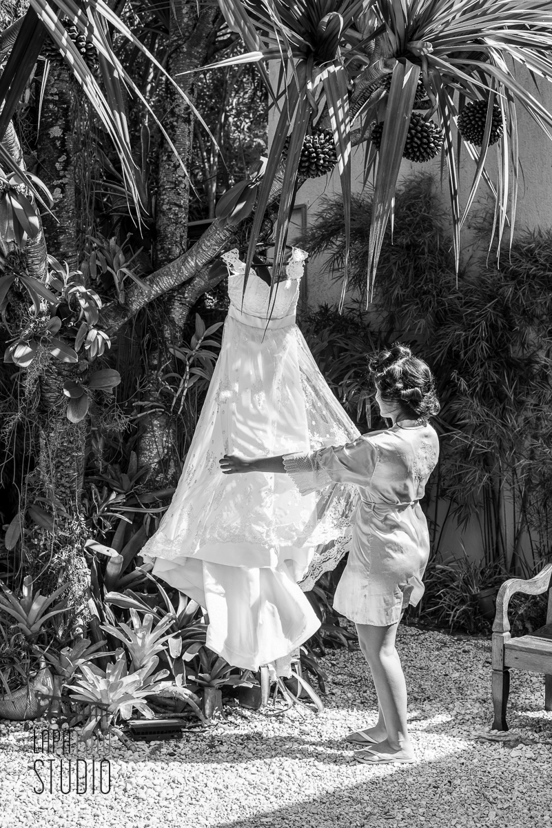 Foto em preto e branco da noiva segurando o vestido