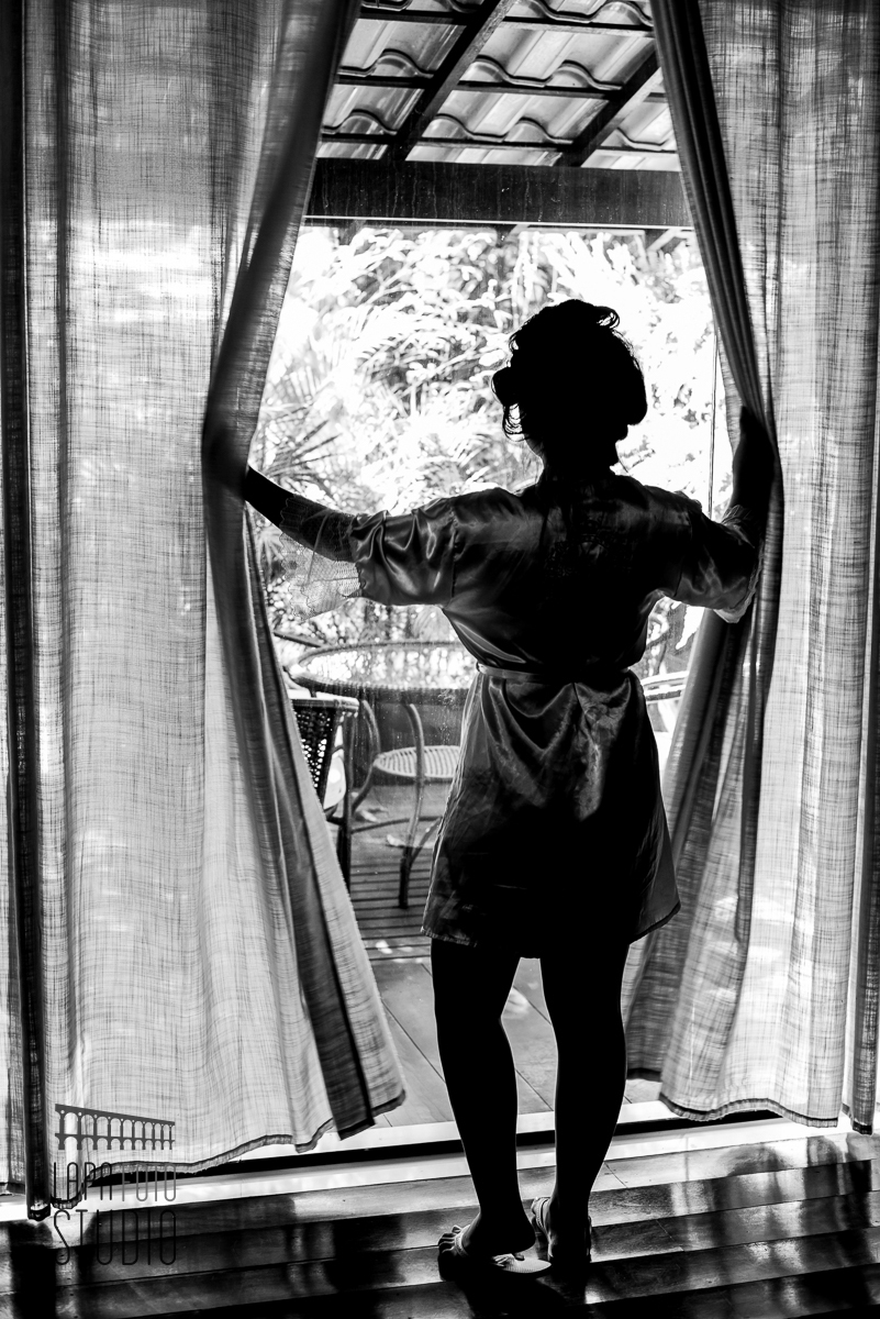 Foto em preto e branco da noiva de costas observando o local da cerimônia de casamento