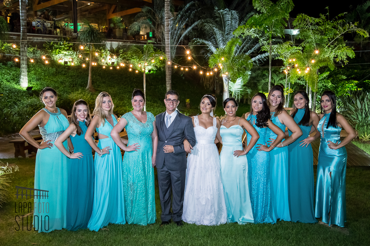 Noivos com as madrinhas de azul durante sessão de fotos posadas do casamento