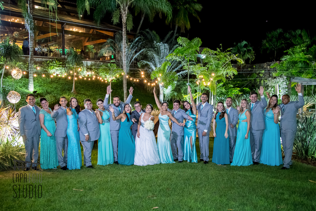 Noivos comemorando com as madrinhas e padrinhos durante sessão de fotos posadas do casamento