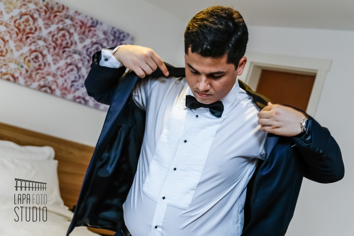 Noivo coloca o terno na preparação para o casamento