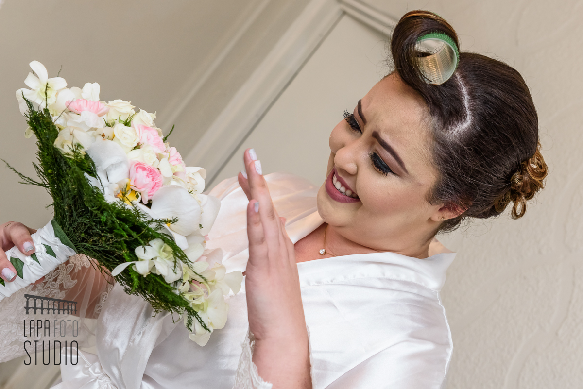 Noiva sorri para o buquê no dia do seu making of