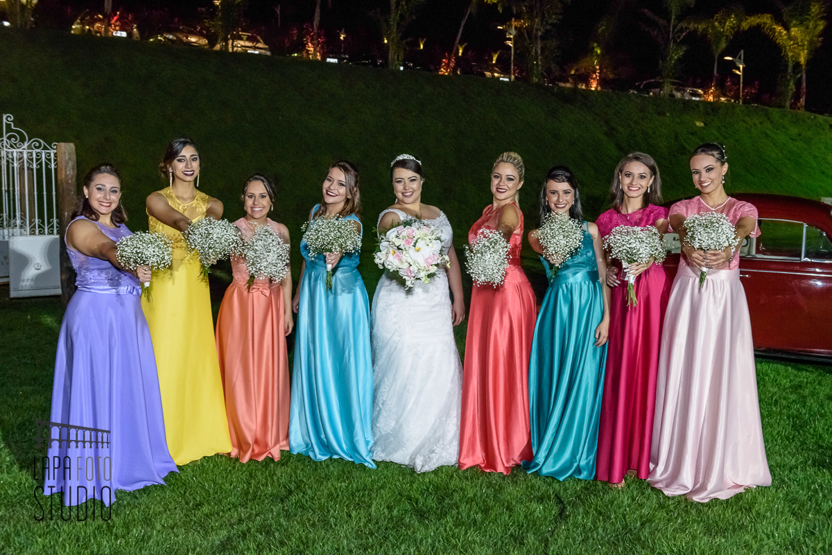 Noiva e madrinhas com buquês durante sessão de fotos posadas após o casamento