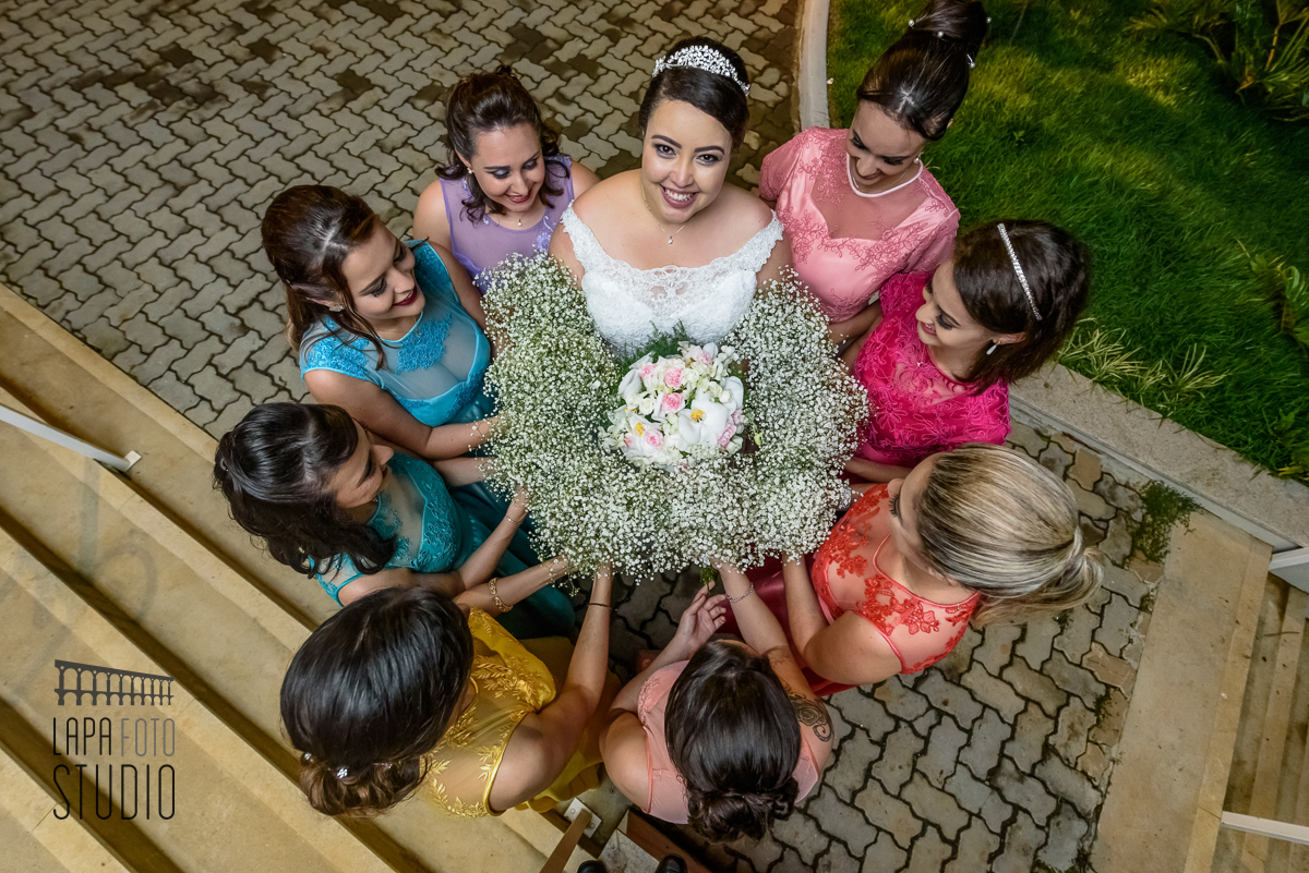 Noiva e madrinhas seguram buquês juntas fazendo um círculo