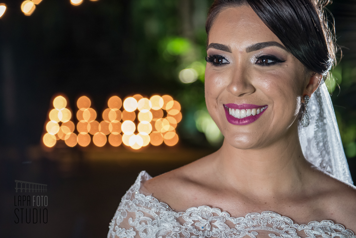 Sorriso da noiva com a palavra amor iluminada ao fundo no Vale dos Sonhos