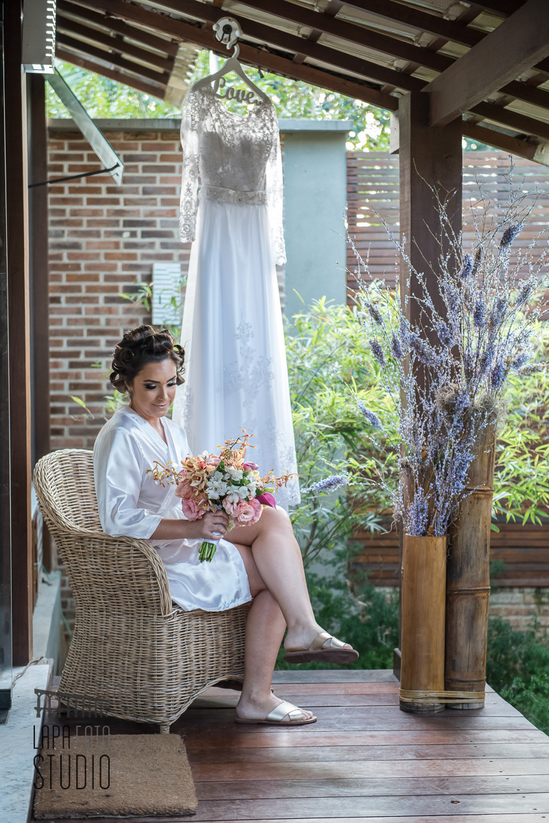 Noiva sentada com buquê na varanda do Espaço Jardins do Vale dos Sonhos
