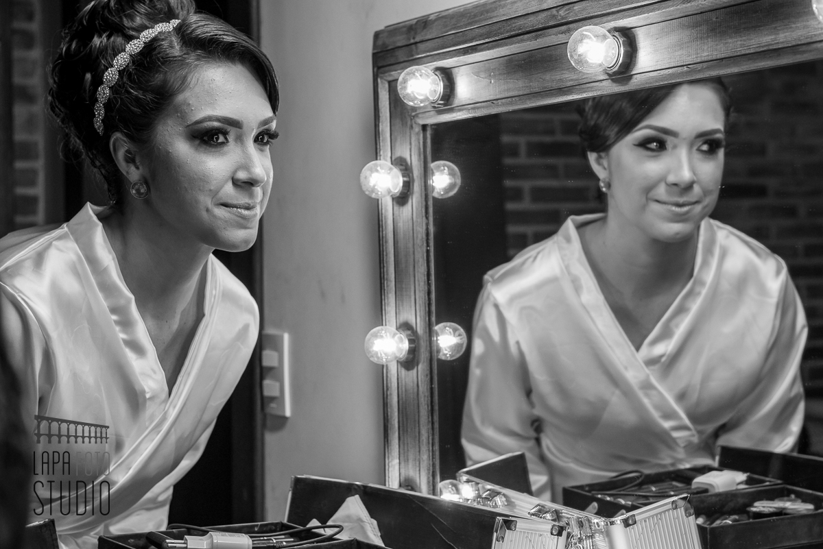Foto em preto e branco da noiva se admirando no making of 
