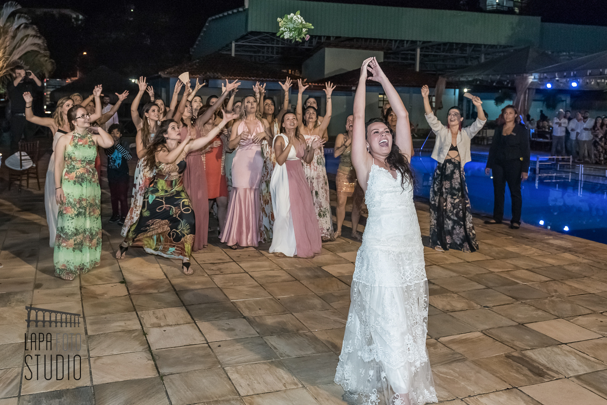 Noiva joga o buquê ao lado da piscina no clube em Mangaratiba