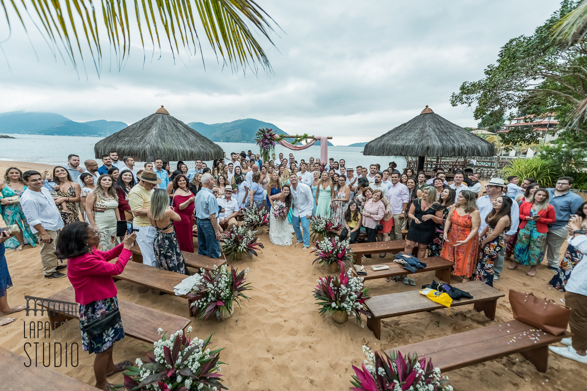 Foto geral de todos os convidados no final da cerimônia de casamento na areia