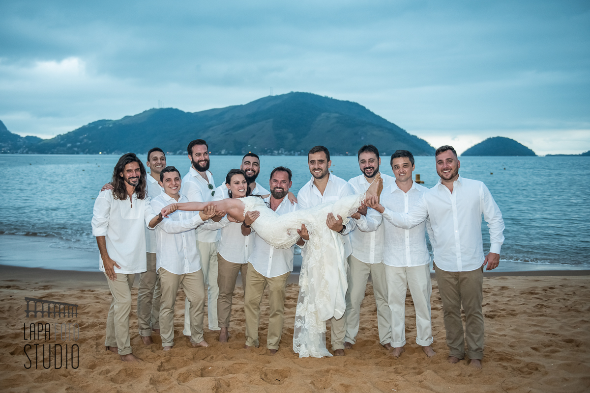 Noiva sendo carregada no colo pelos padrinhos durante sessão de fotos posadas pós casamento