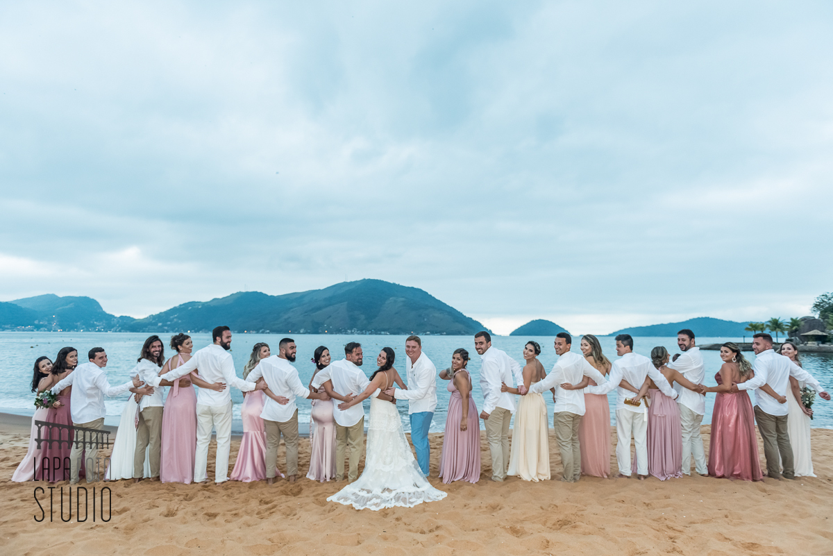 Todos os padrinhos e madrinhas juntos com os noivos na sessão de fotos posadas pós casamento