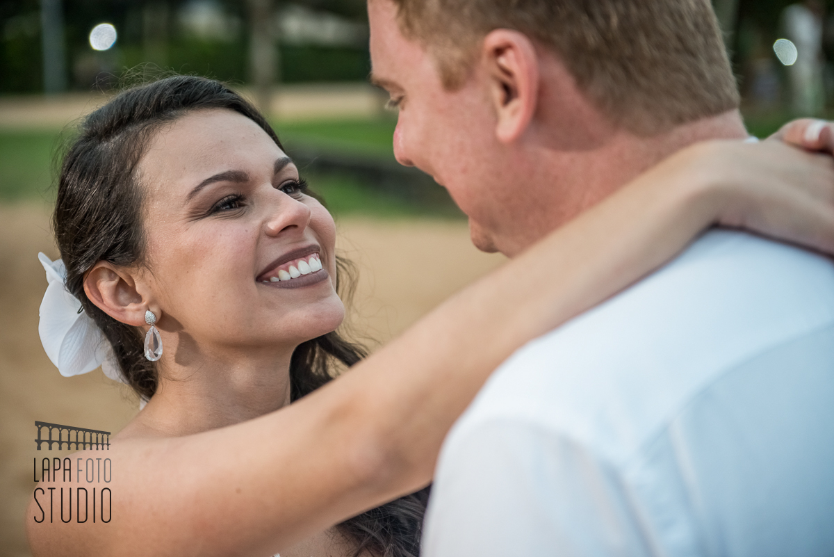 Noiva sorri para o noivo durante sessão de fotos do casal pós casamento