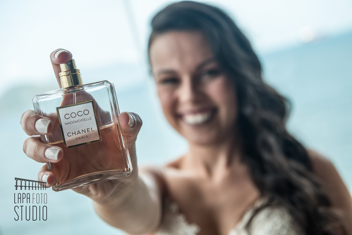 Noiva com o perfume com o mar ao fundo na praia de mangaratiba