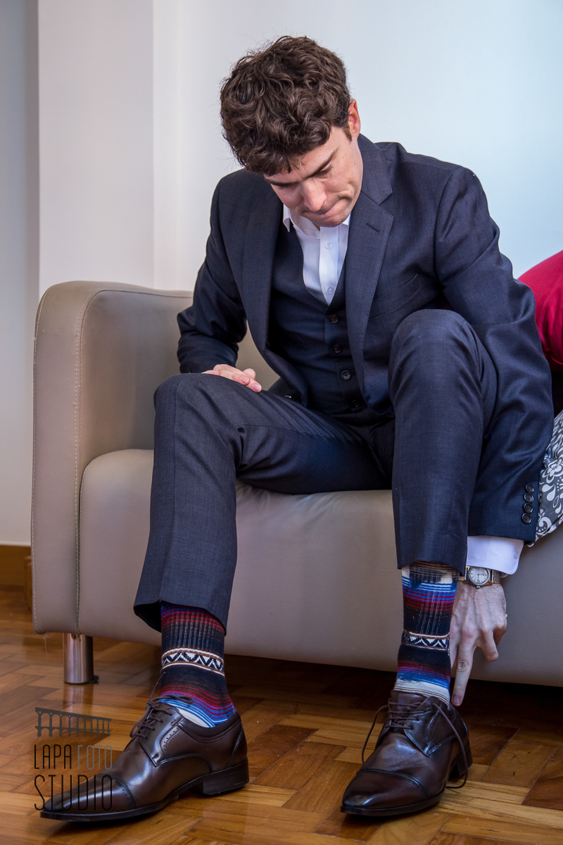 Noivo americano com meias diferentes colocando o sapato durante making of em Copacabana